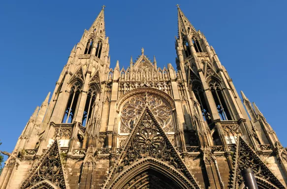 Low angle perspective of a large Gothic Catholic church with a clear blue sky, Saint-Ouen Abbey, Rouen