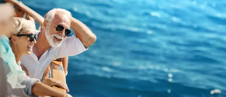 happy couple smiling onboard yacht cruise sailing on beautiful blue waters